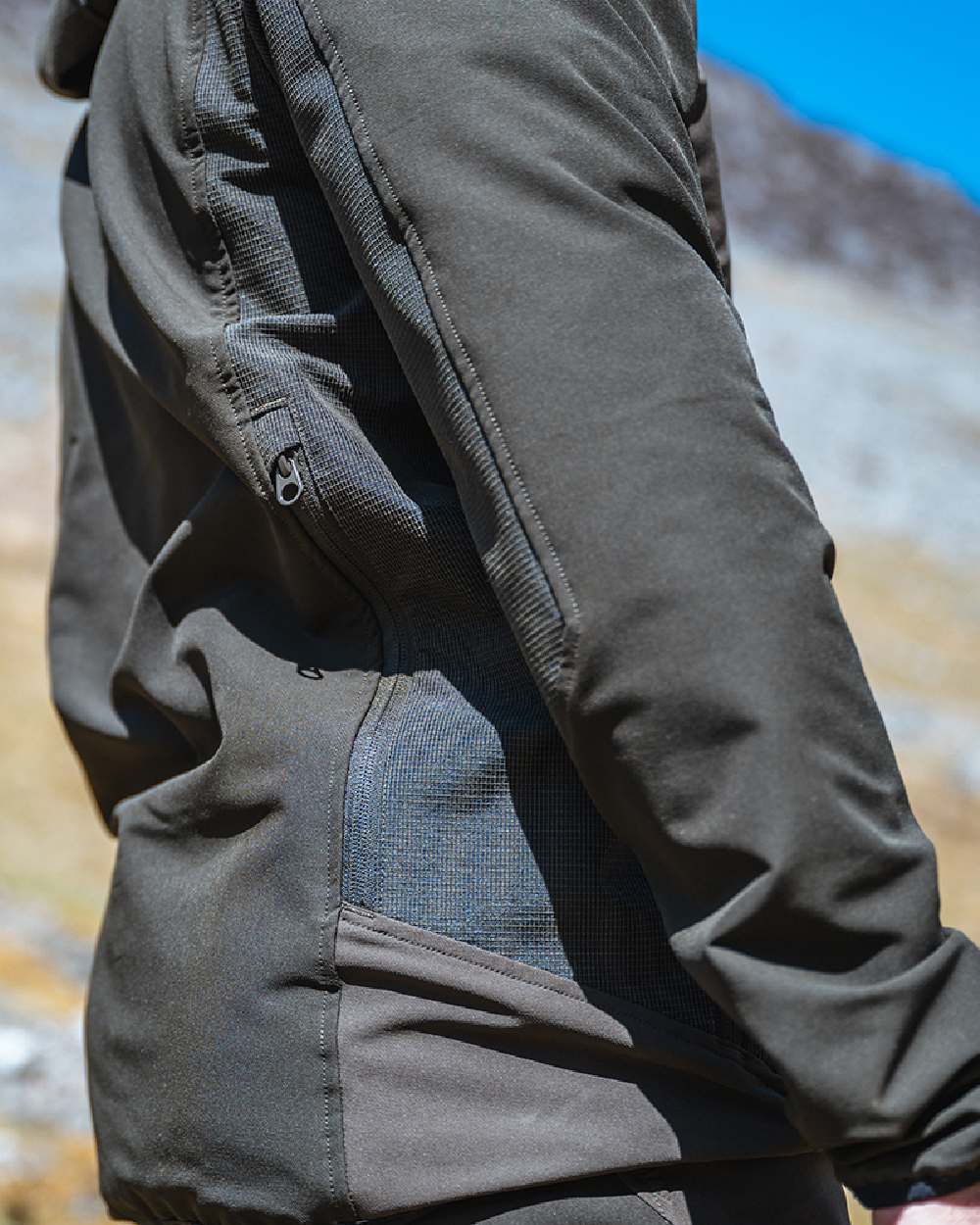 Green Coloured Hoggs of Fife Mens Ardross 4 Way Active Jacket on blurry background #colour_green