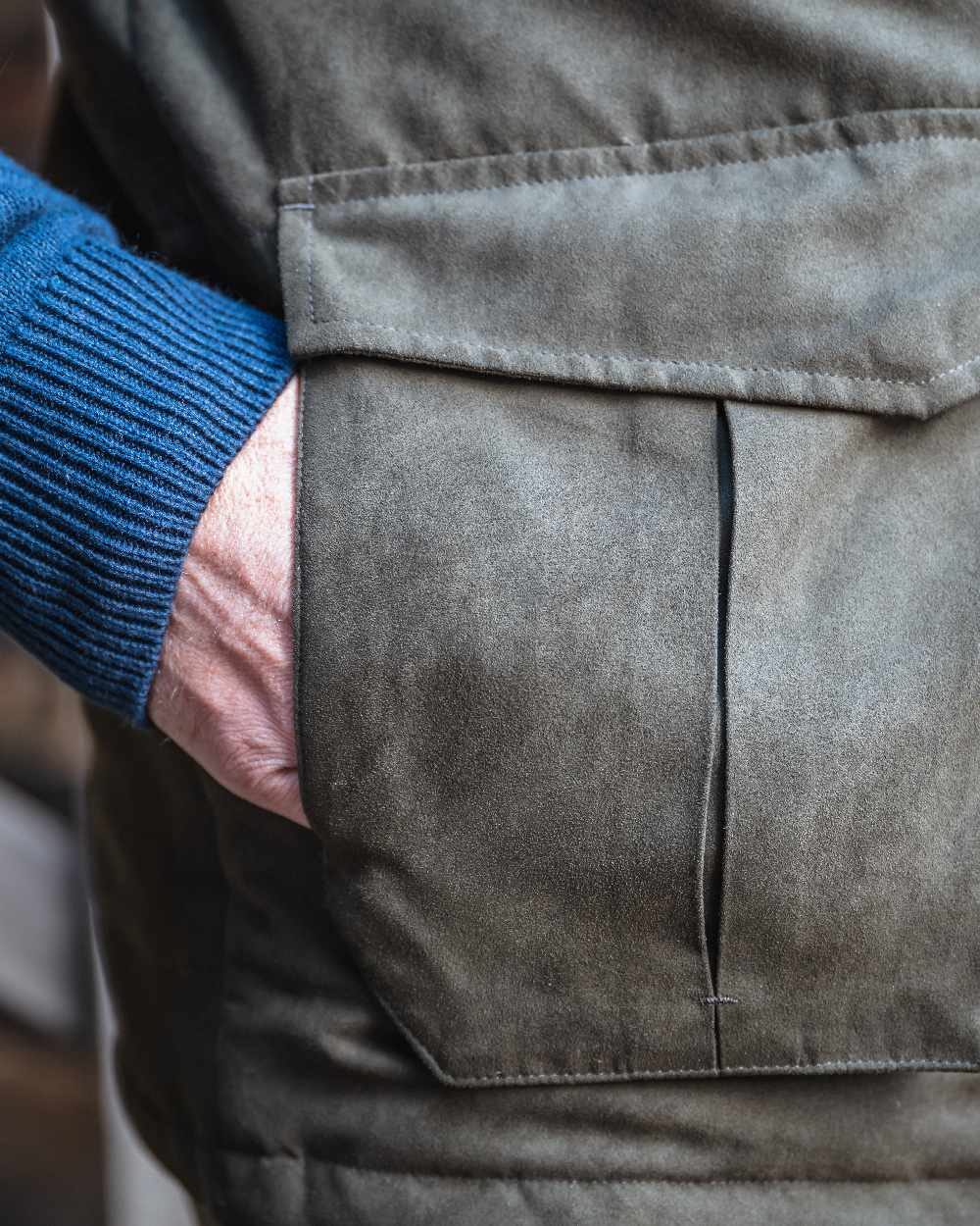 Loden coloured Hoggs of Fife Mens Glenbervie Quilted Gilet on blurry background #colour_loden