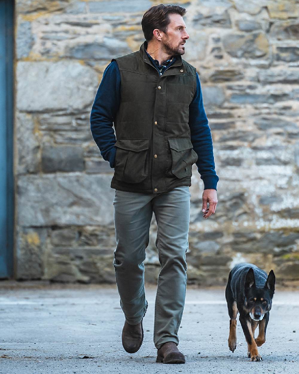 Loden coloured Hoggs of Fife Mens Glenbervie Quilted Gilet on wall background #colour_loden