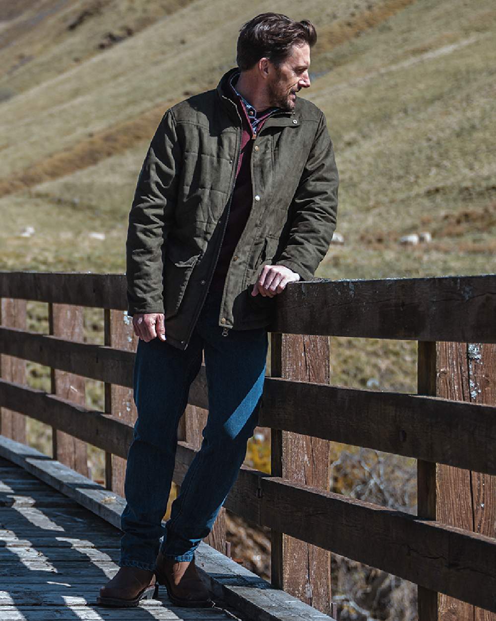Loden coloured Hoggs of Fife Mens Glenesk Quilted Jacket on mountain background #colour_loden