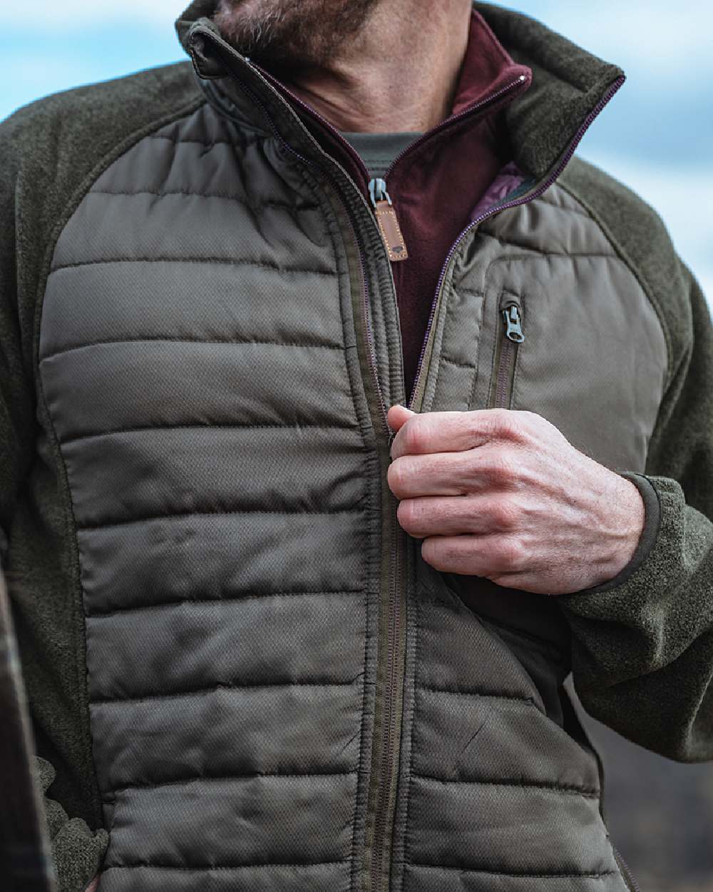 Dark Forest Marl Coloured Hoggs of Fife Mens Melville Hybrid Jacket on blurry background #colour_dark-forest-marl