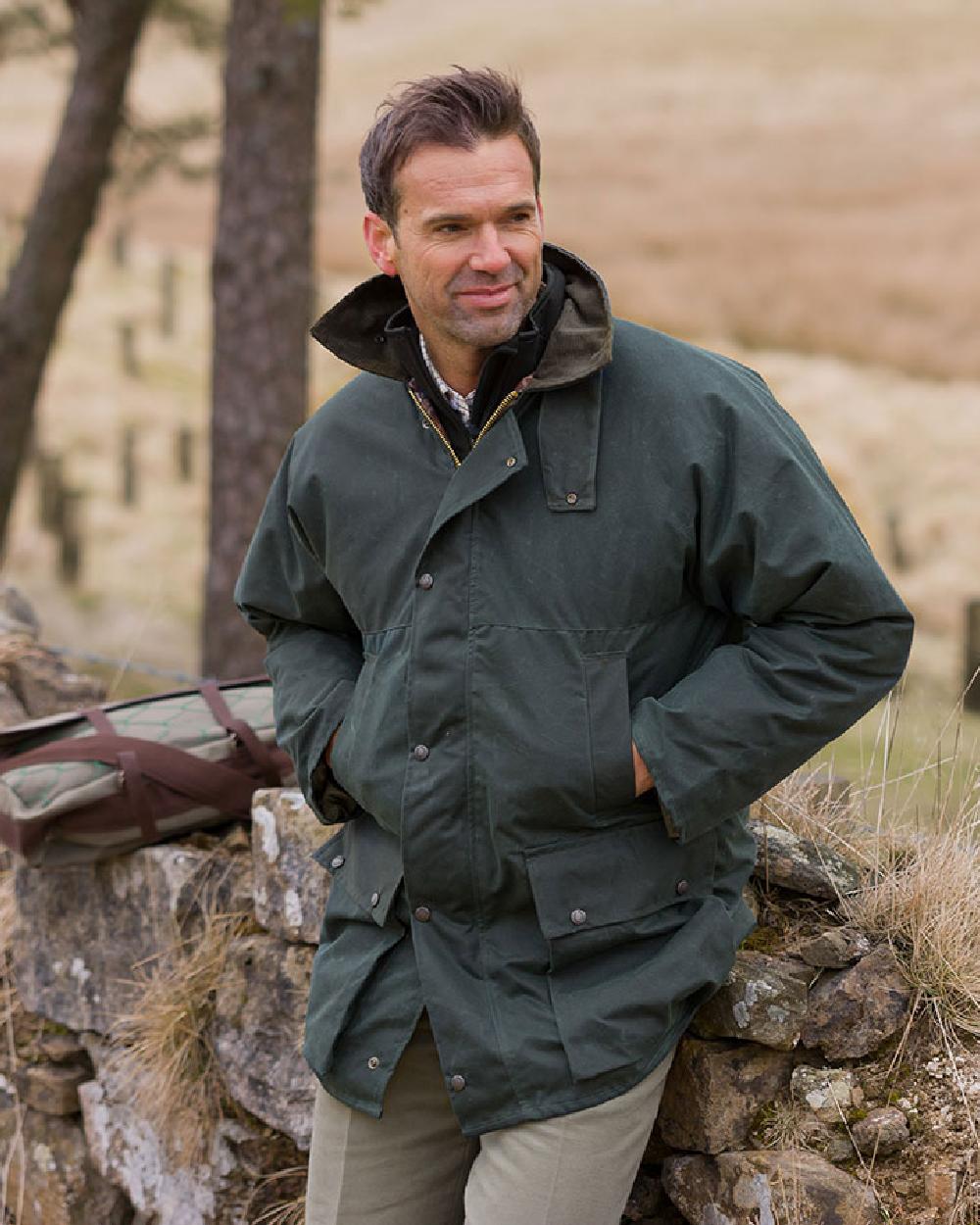 Olive Coloured Hoggs of Fife Padded Waxed Jacket on countryside background #colour_olive