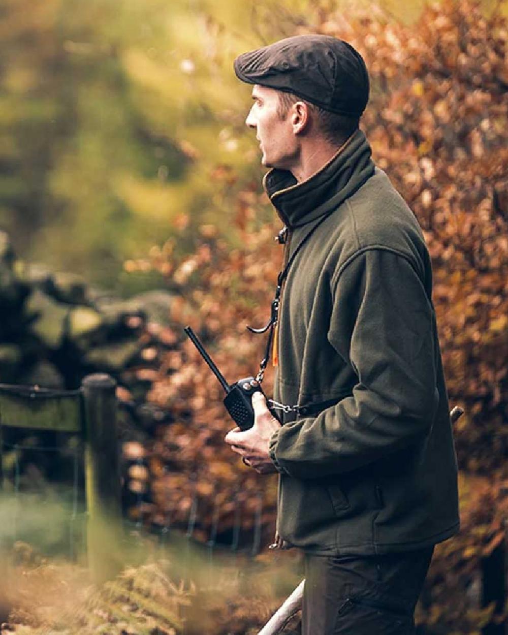 Olive coloured Jack Pyke Ashcombe Flat Cap on tree background #colour_olive