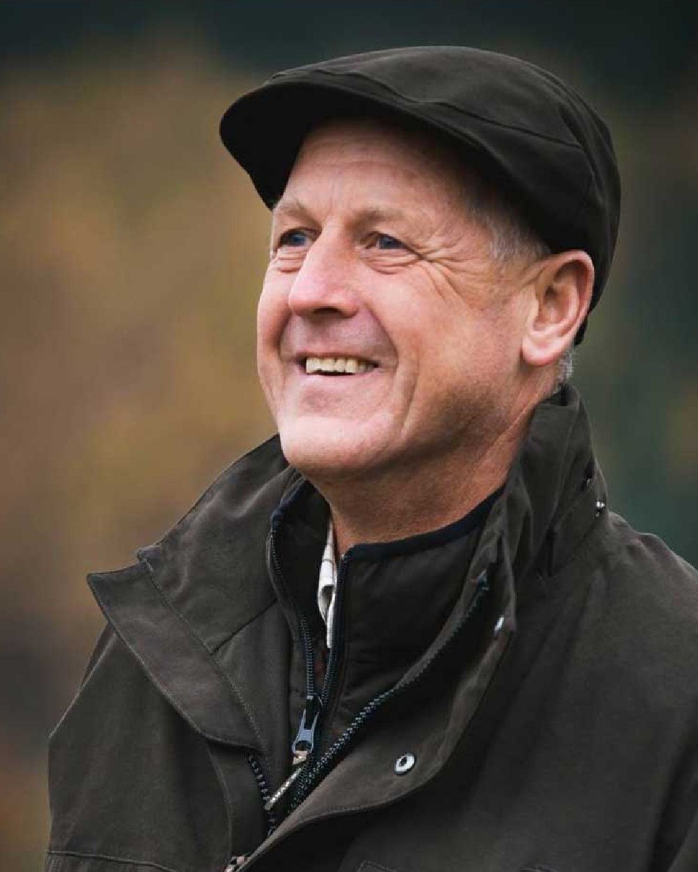 Olive coloured Jack Pyke Ashcombe Flat Cap on blurry background #colour_olive
