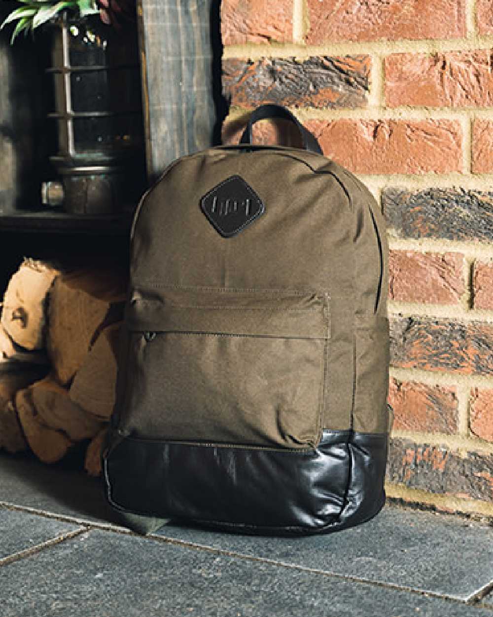 Green coloured Jack Pyke Canvas Back Pack on brick wall background #colour_green