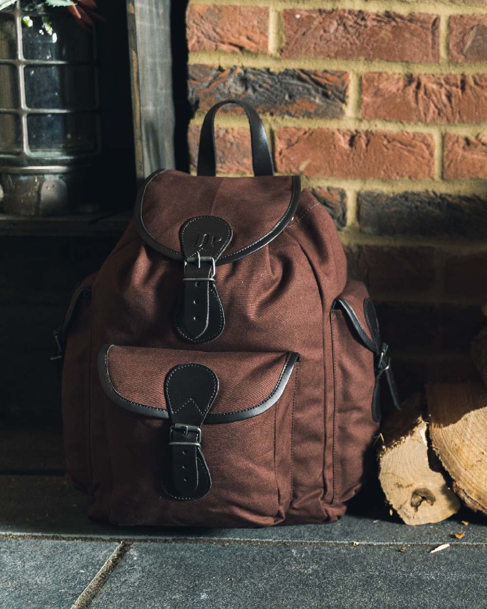 Brown coloured Jack Pyke Canvas Day Pack on wall background #colour_brown