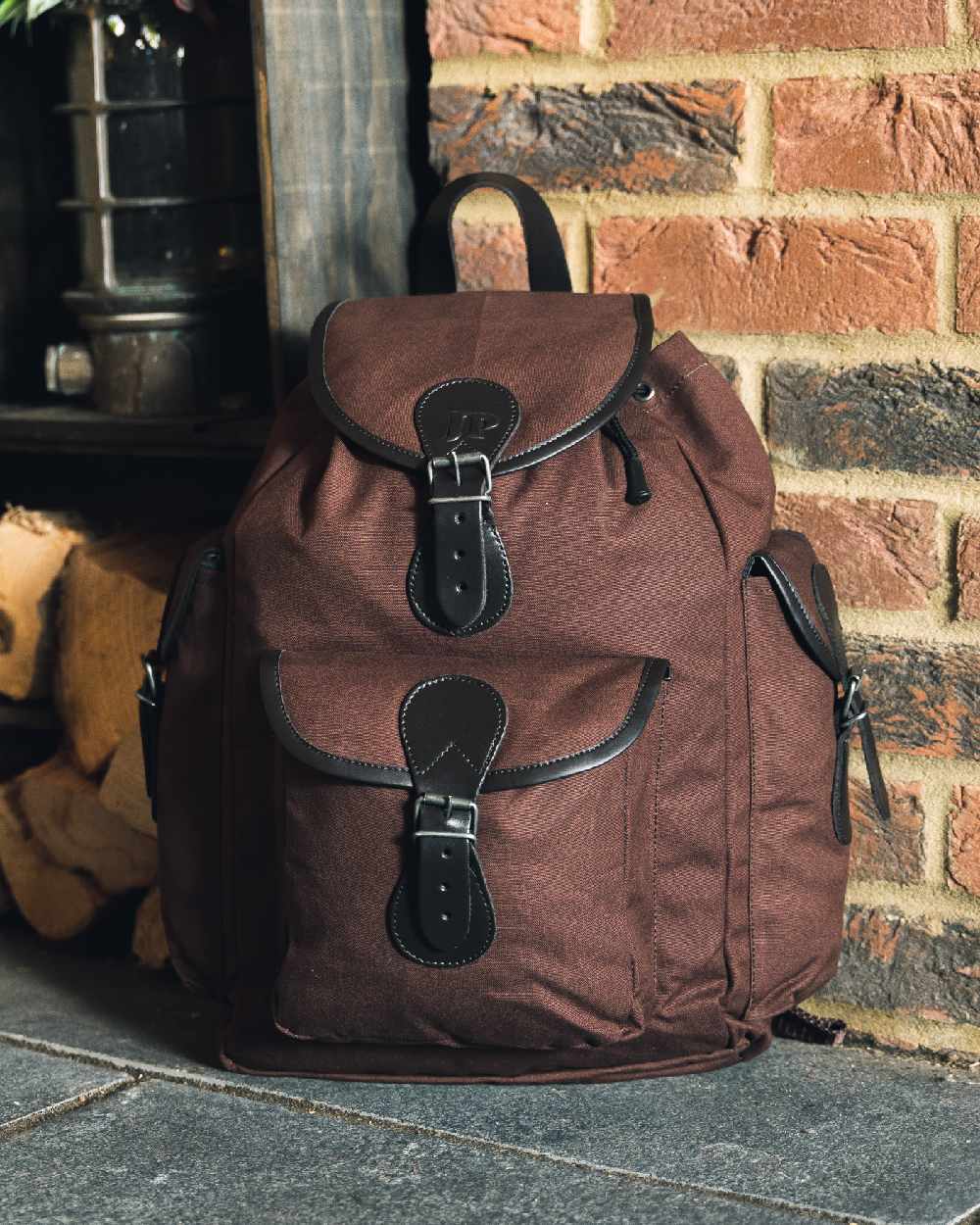 Brown coloured Jack Pyke Canvas Day Pack on wall background #colour_brown