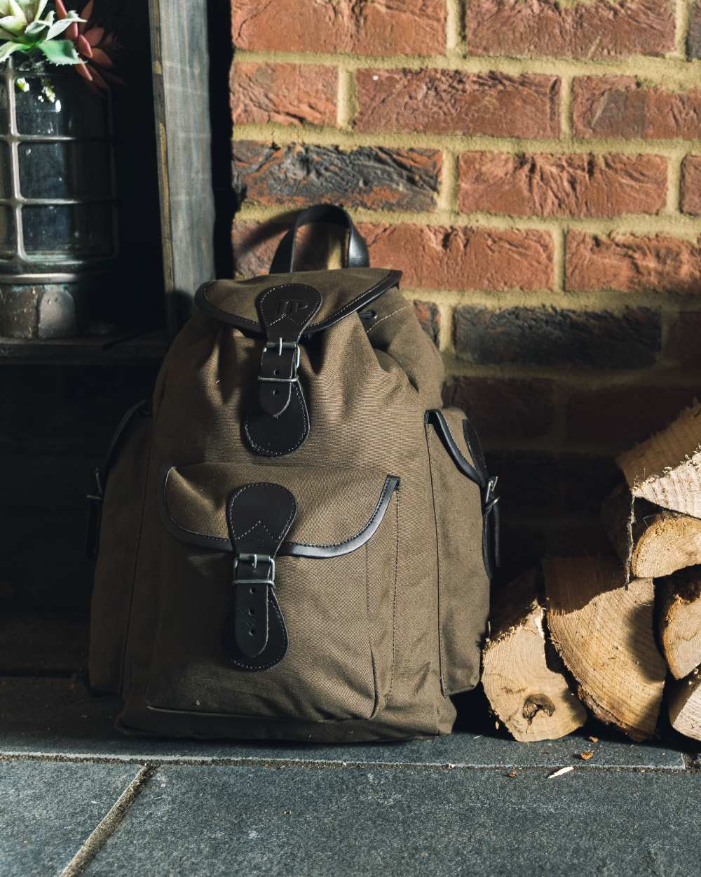 Green coloured Jack Pyke Canvas Day Pack on wall background #colour_green