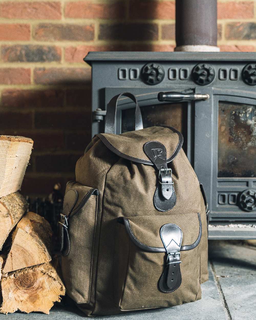 Green coloured Jack Pyke Canvas Day Pack on wall background #colour_green