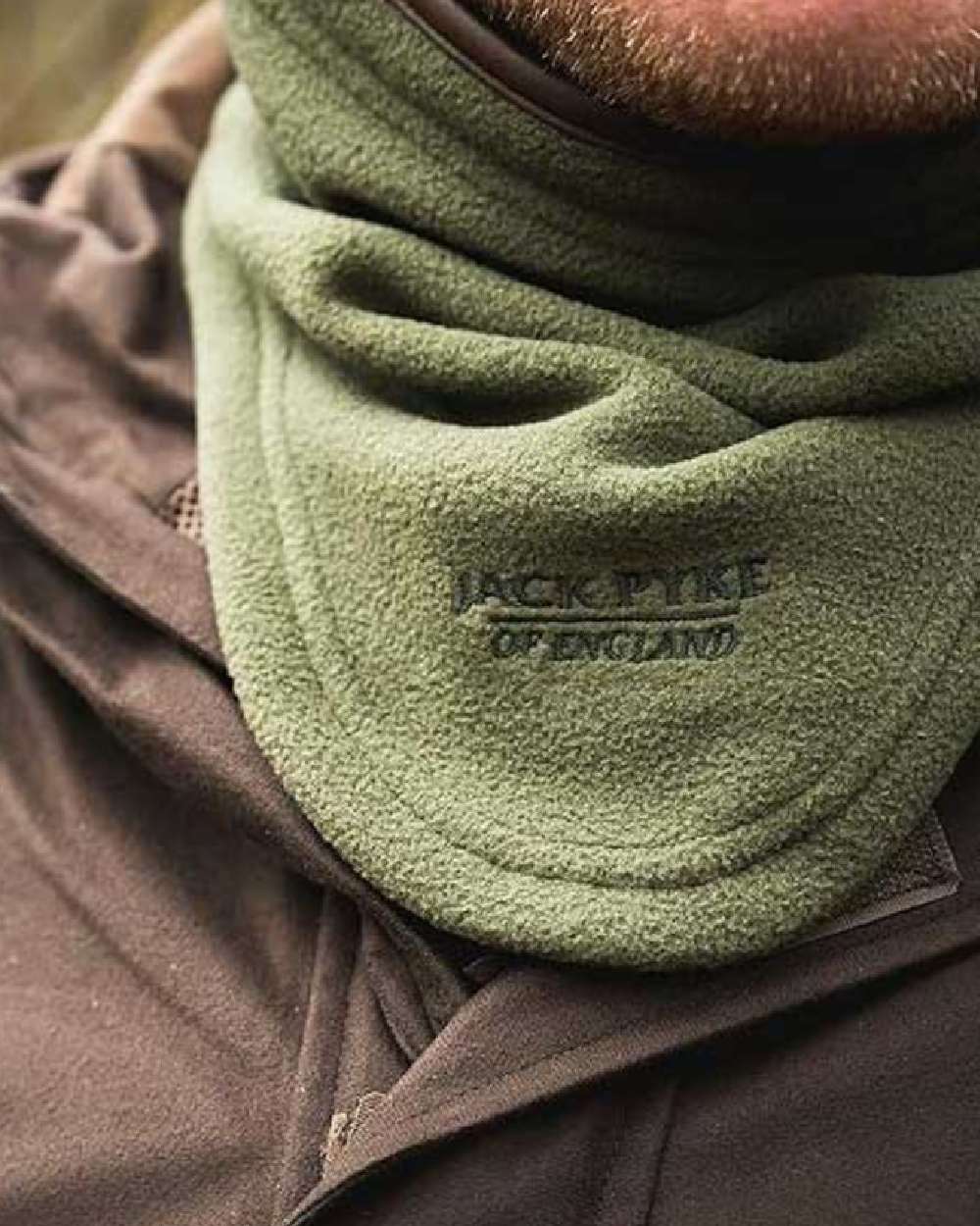 Light Olive coloured Jack Pyke Countryman Fleece Neck Gaiter on blurry background #colour_light-olive