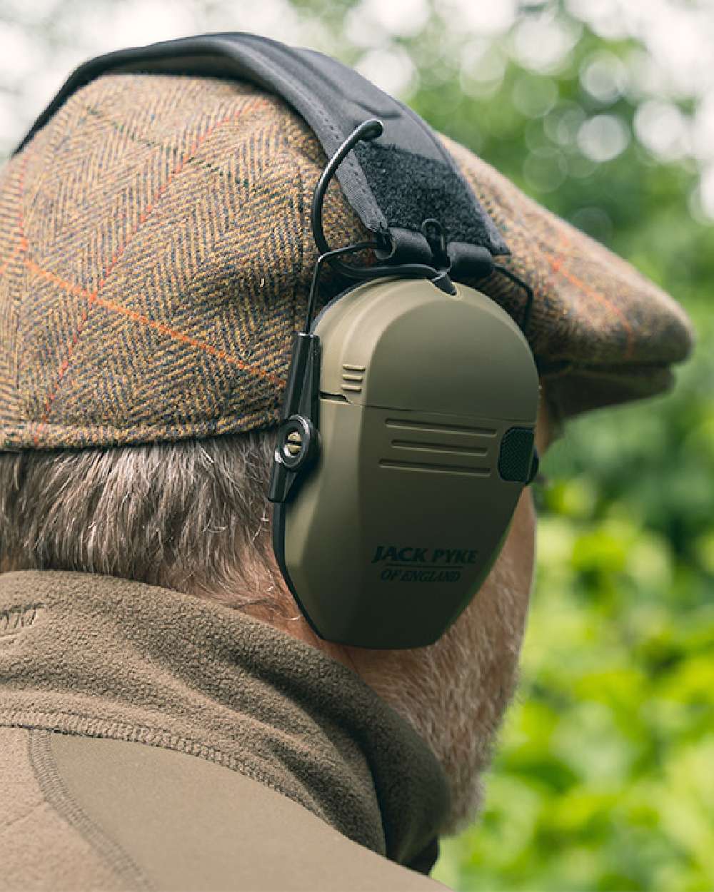 Green coloured Jack Pyke Electronic Ear Defenders on forest background #colour_green