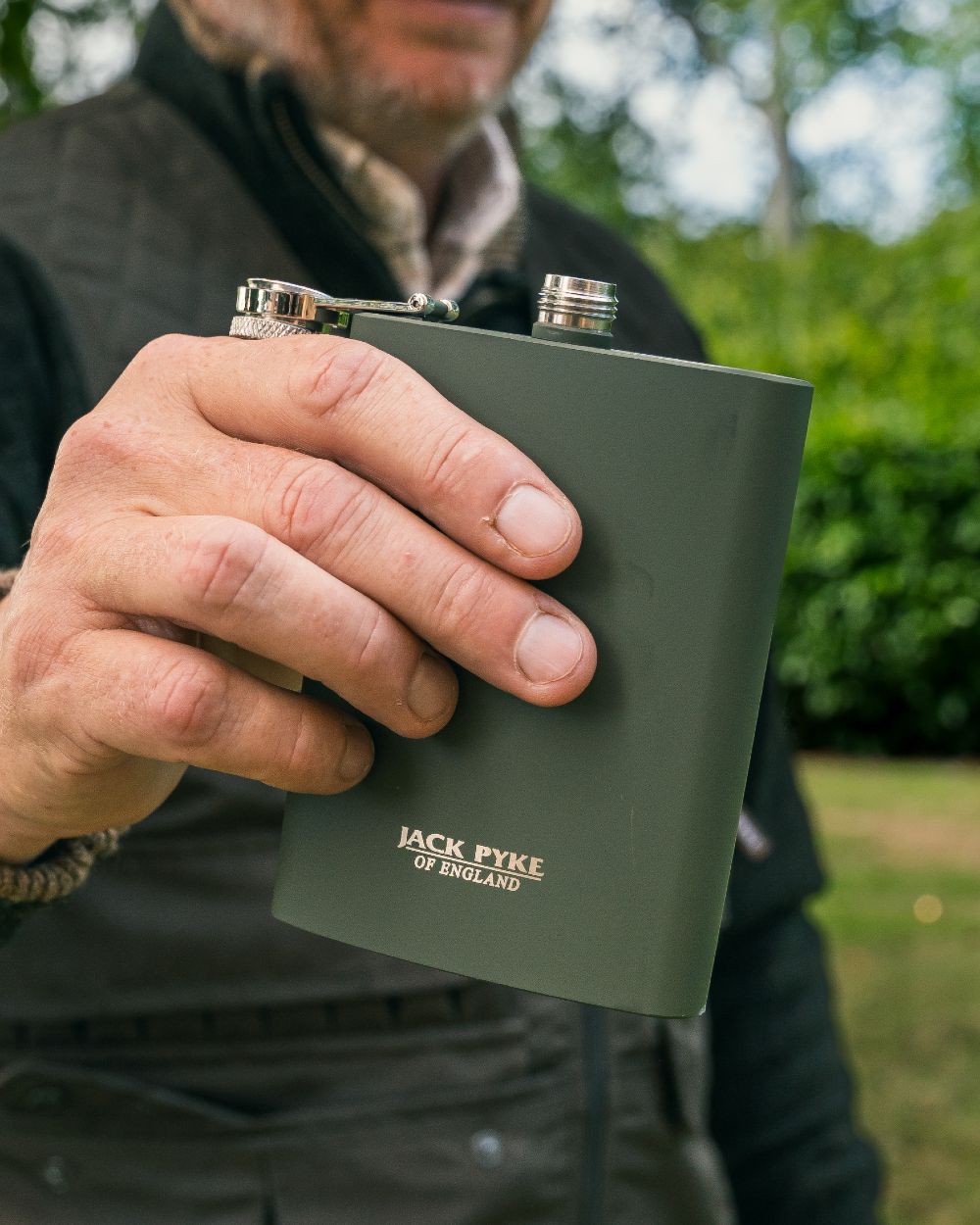 Green coloured Jack Pyke Hip Flask on forest background #colour_green