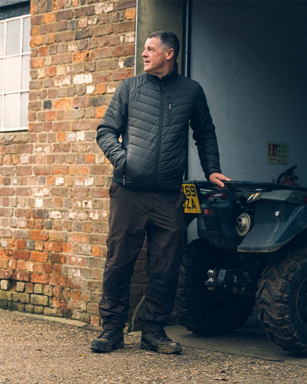 Green coloured Jack Pyke Hybrid Jacket on brick wall background #colour_green