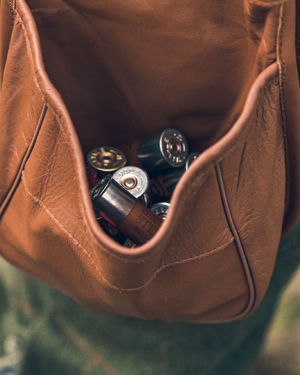 Tan coloured Jack Pyke Leather Cartridge Pouch on blurry background #colour_tan
