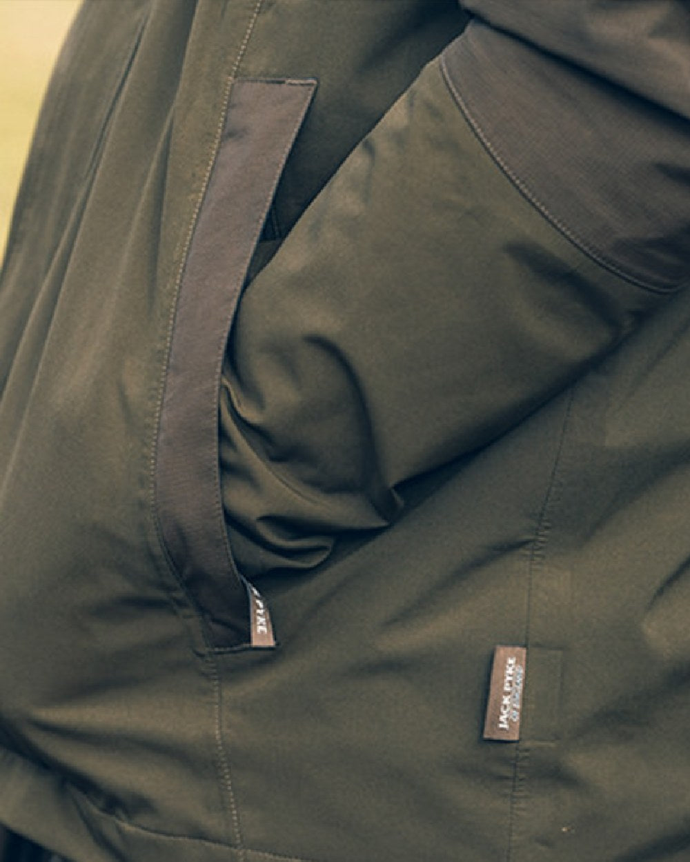 Green coloured Jack Pyke Pro-Lite Hunters Jacket on blurry background #colour_green