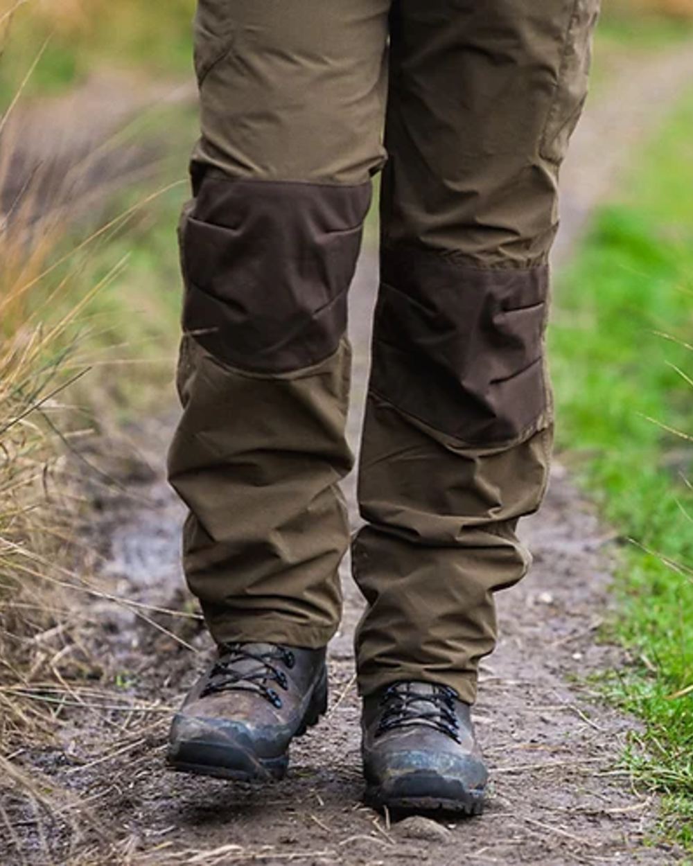 Green coloured Jack Pyke Weardale Hunting Trousers on mud background #colour_green