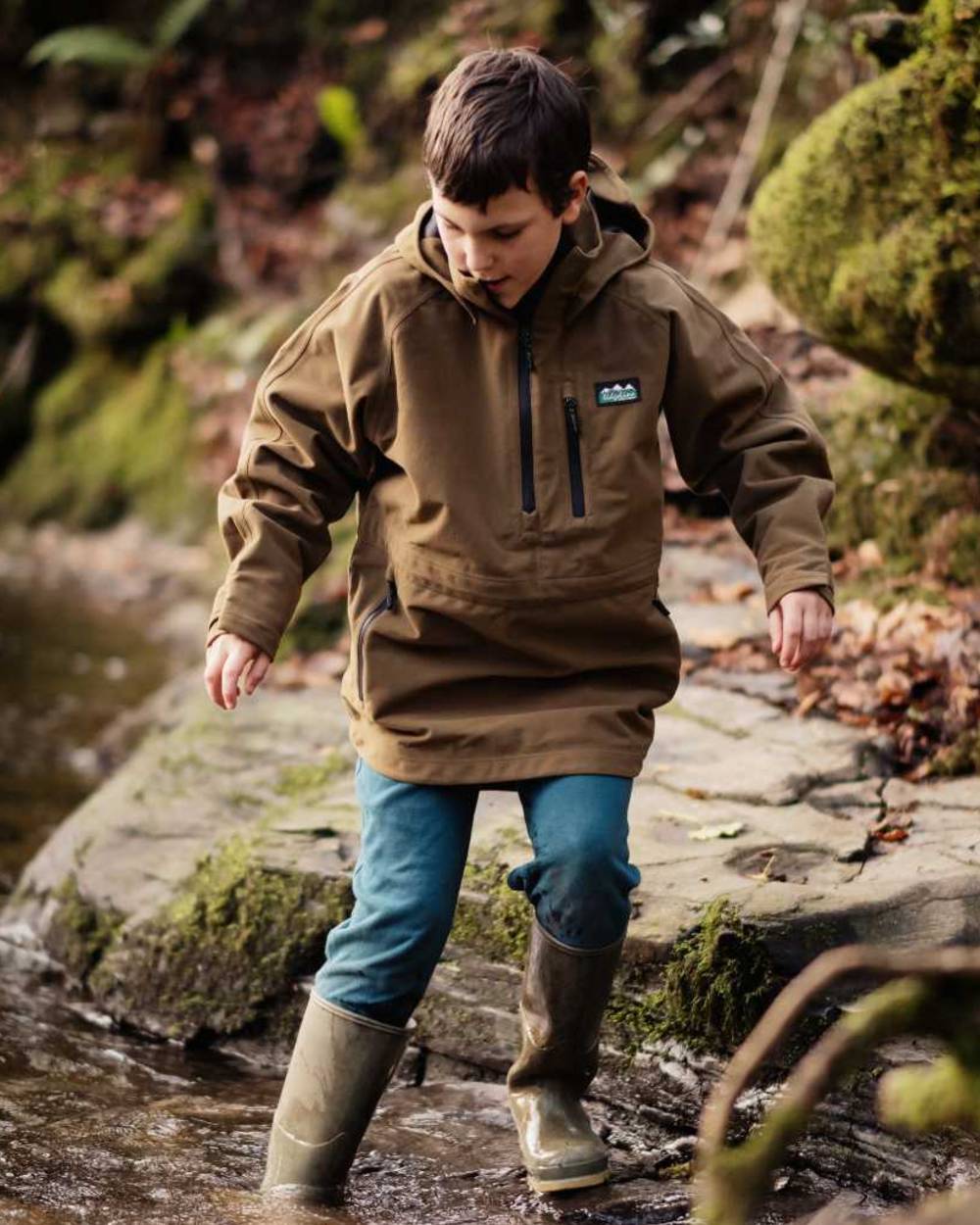 Teak coloured Ridgeline Kids Monsoon Smock on forest background #colour_teak