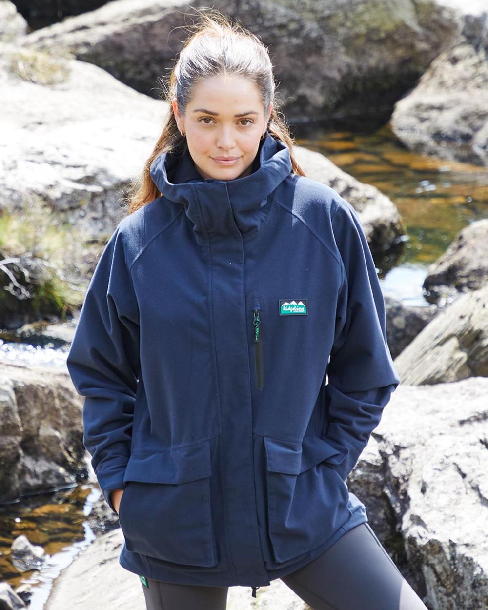 Navy coloured Ridgeline Ladies Rhea Jacket on rock background #colour_navy