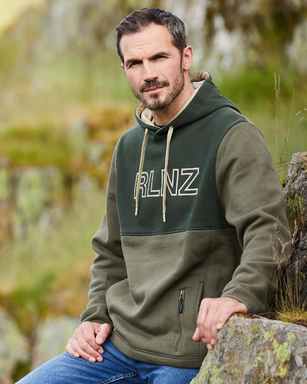 Olive coloured Ridgeline Mens South Island Hoodie on forest background #colour_olive