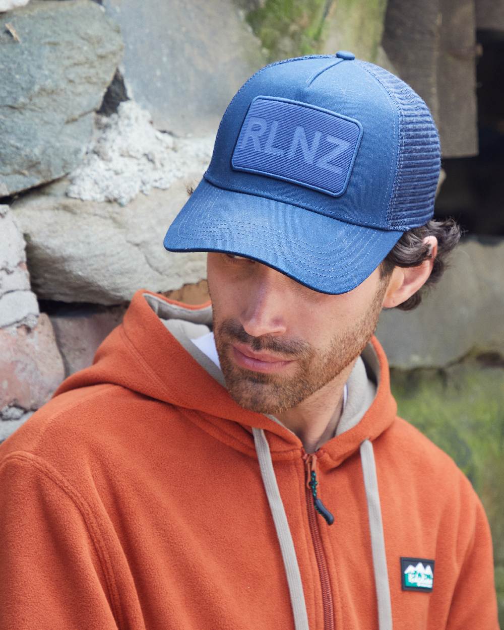 Navy Coloured Ridgeline RLNZ Trucker Cap on outdoor background #colour_navy