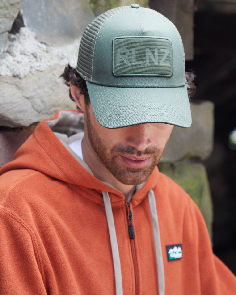 Olive Coloured Ridgeline RLNZ Trucker Cap on outdoor background #colour_olive