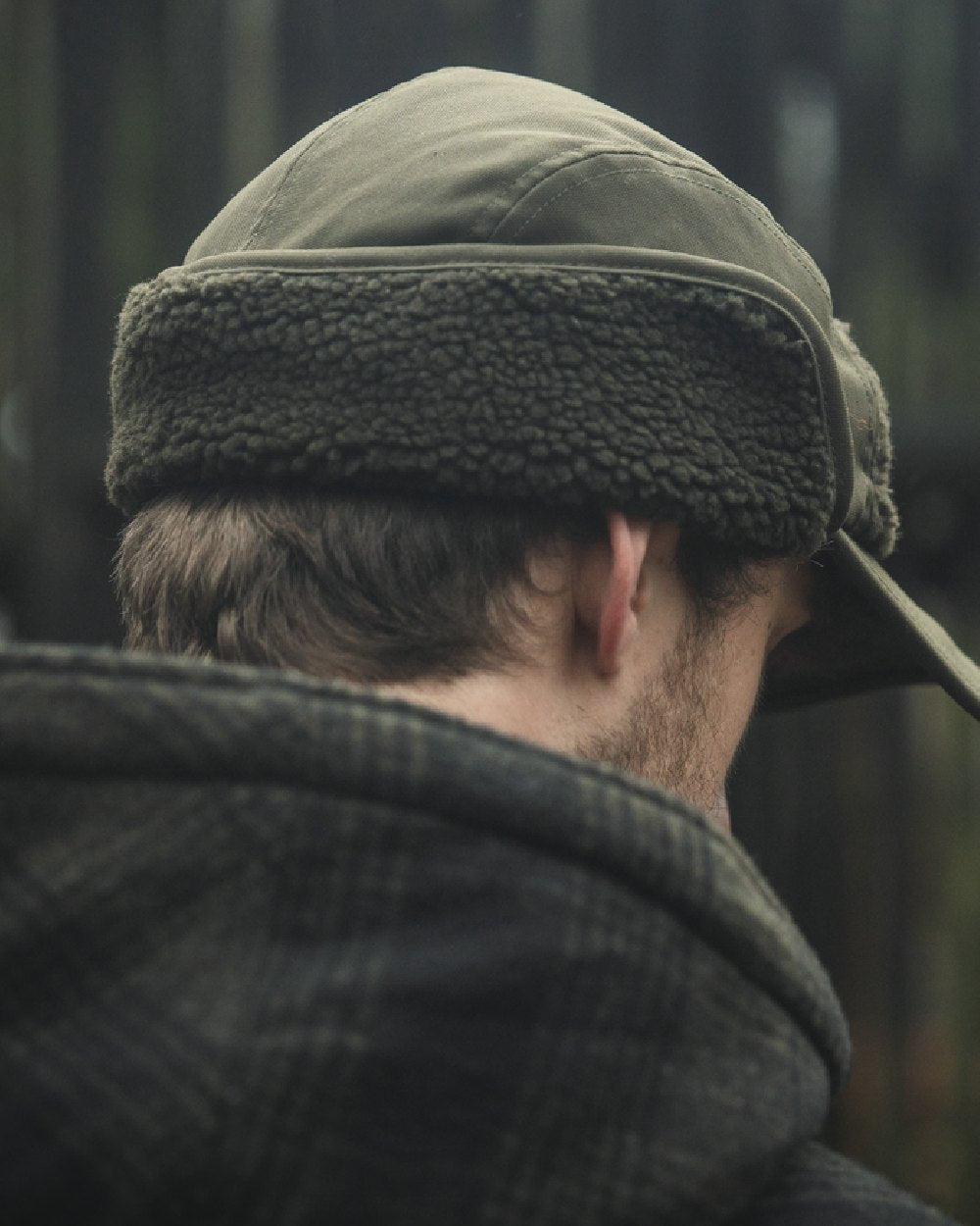 Pine Green coloured Seeland Mens Teddy Fold Down Cap on forest background #colour_pine-green