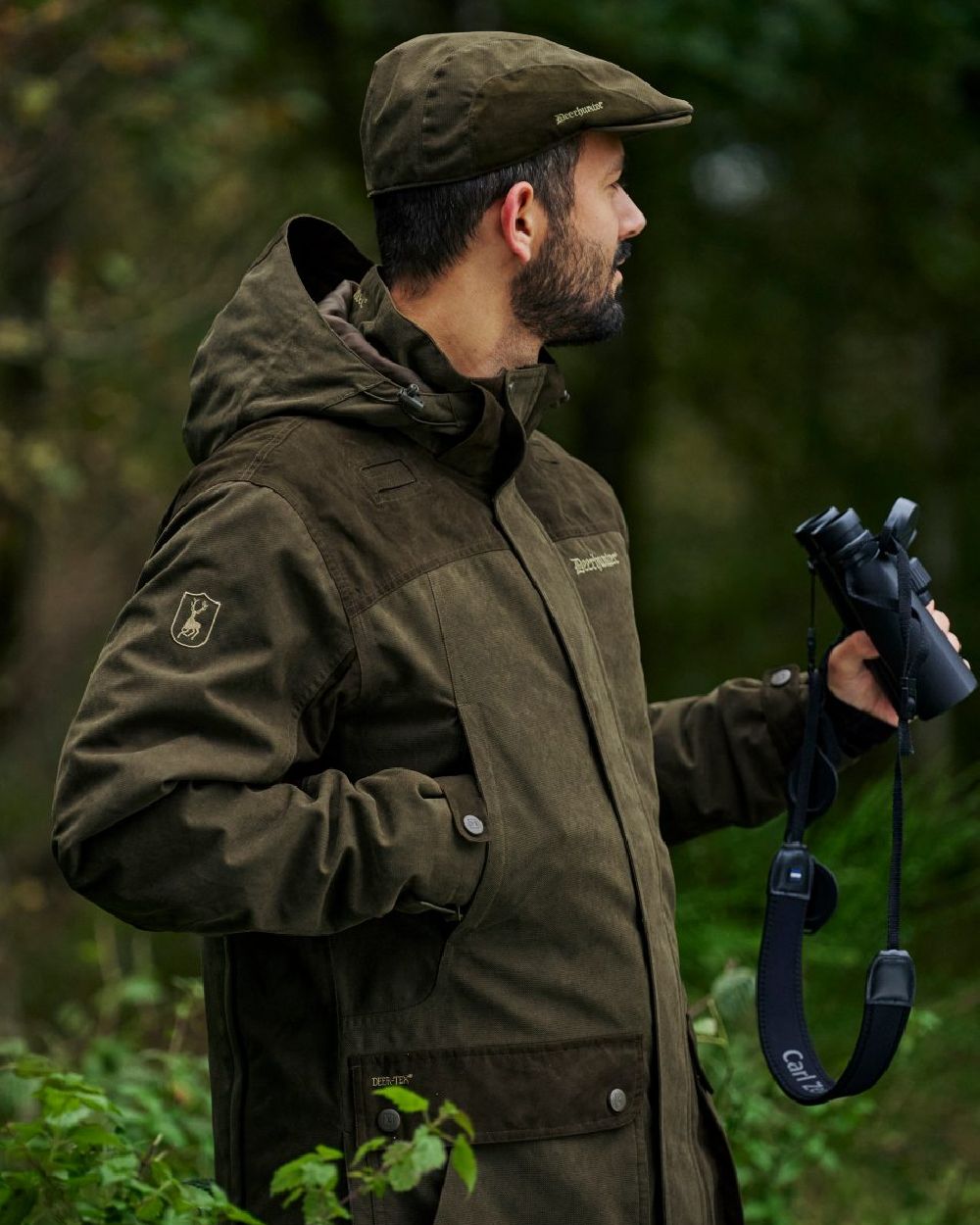Tarmac Green coloured Deerhunter Eagle Flat Cap on forest background #colour_tarmac-green