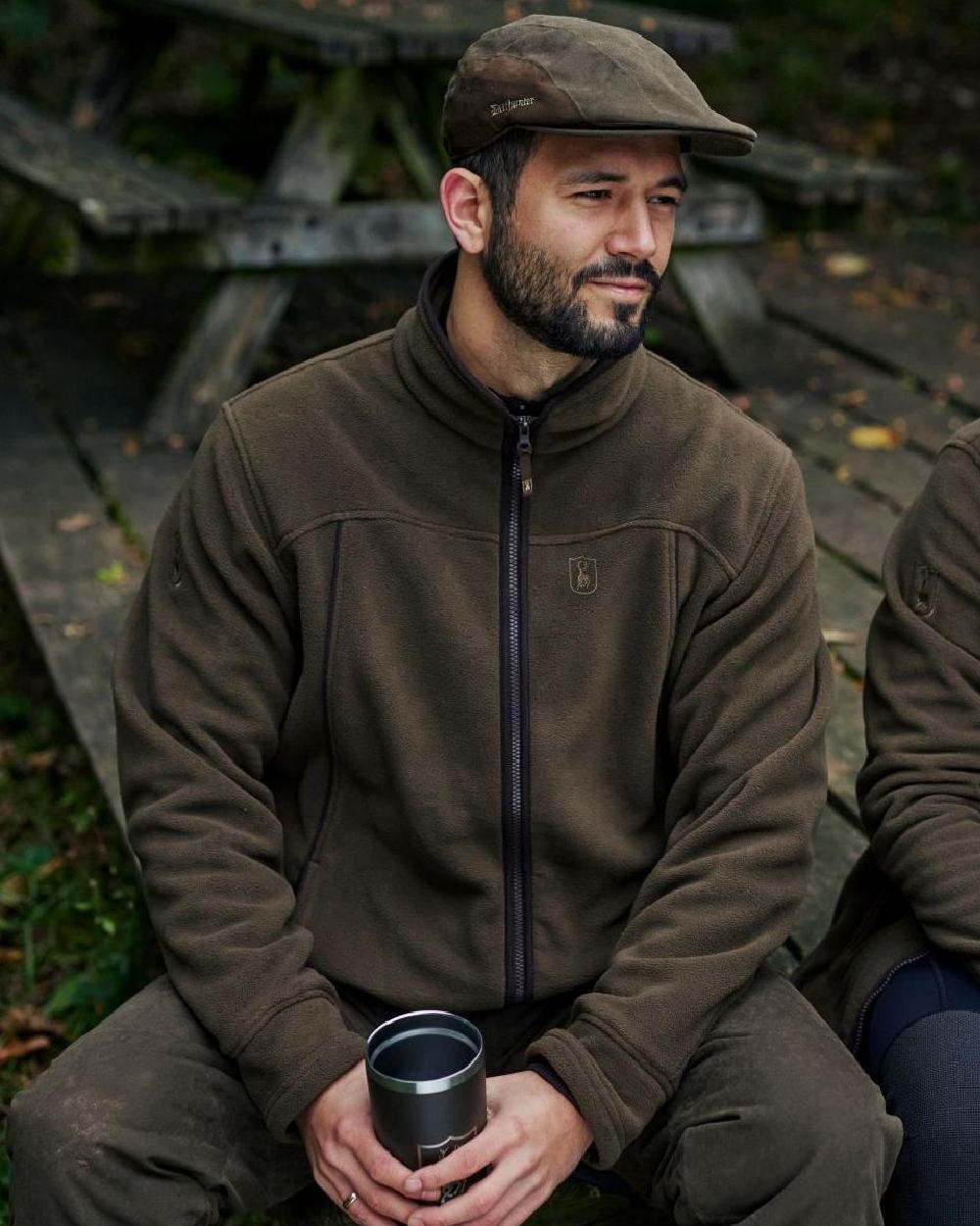 Tarmac Green coloured Deerhunter Eagle Flat Cap on wooden bench background #colour_tarmac-green