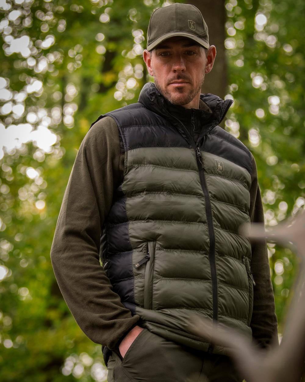 Rifle Green coloured Deerhunter Northward Padded Waistcoat on Forest background #colour_rifle-green