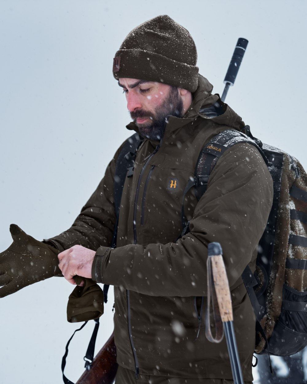 Willow Green Coloured Harkila Logmar HWS Packable Jacket on snow background #colour_willow-green