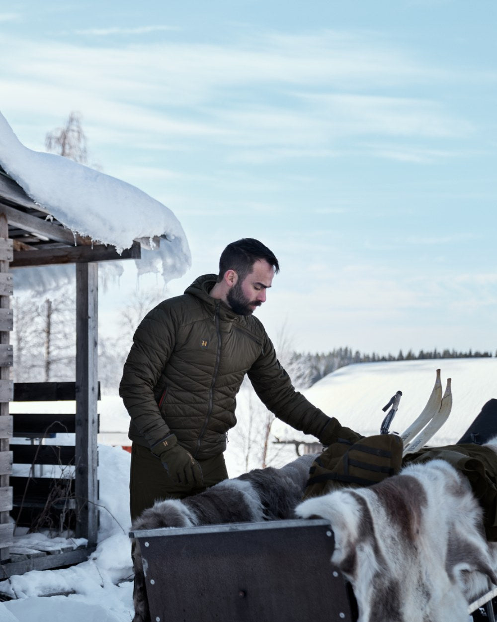 Willow Green Coloured Harkila Logmar Insulated Packable Hooded Jacket on snow background #colour_willow-green