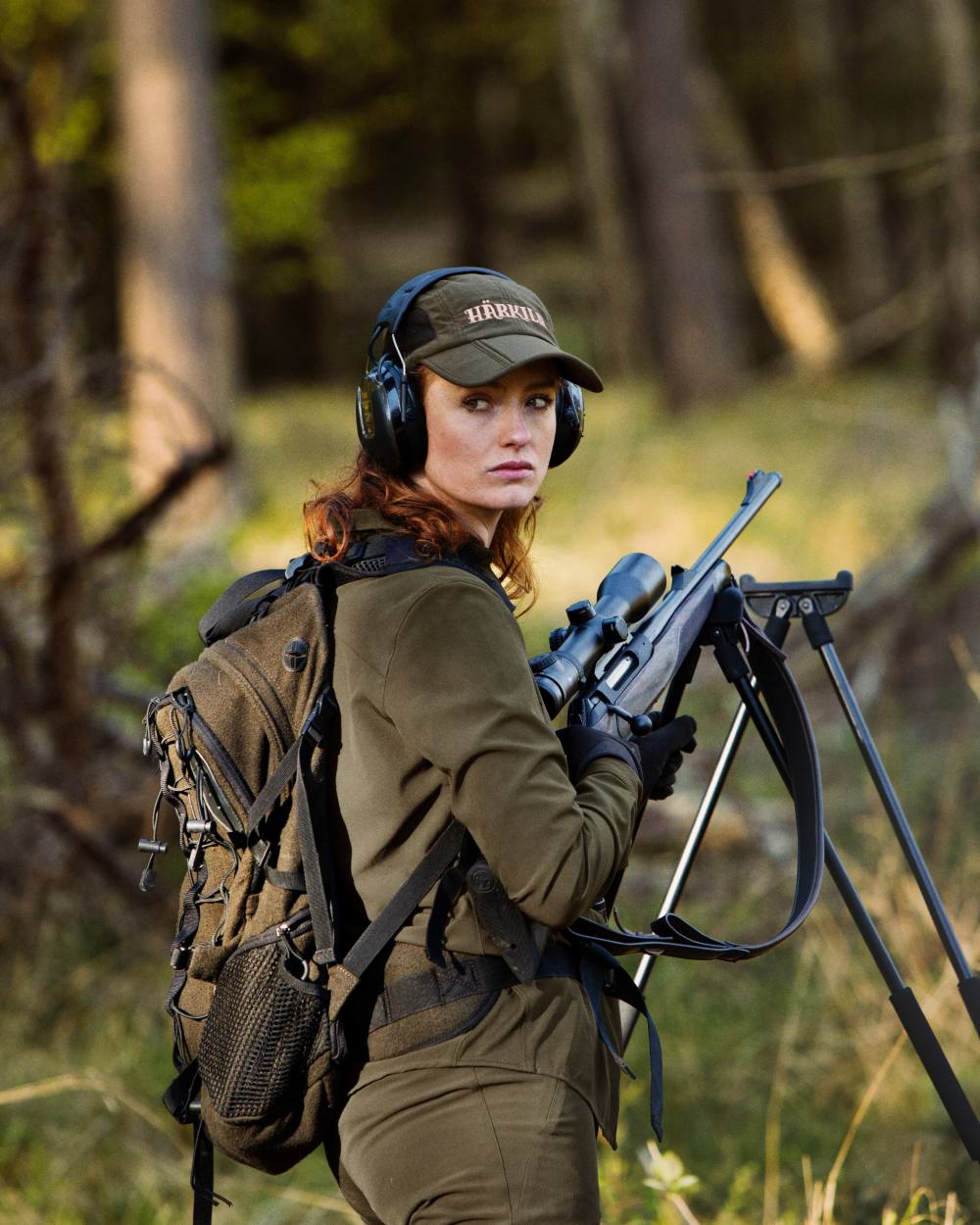 Hunting Green Coloured Harkila Reisa Rucksack Backpack on forest background #colour_hunting-green