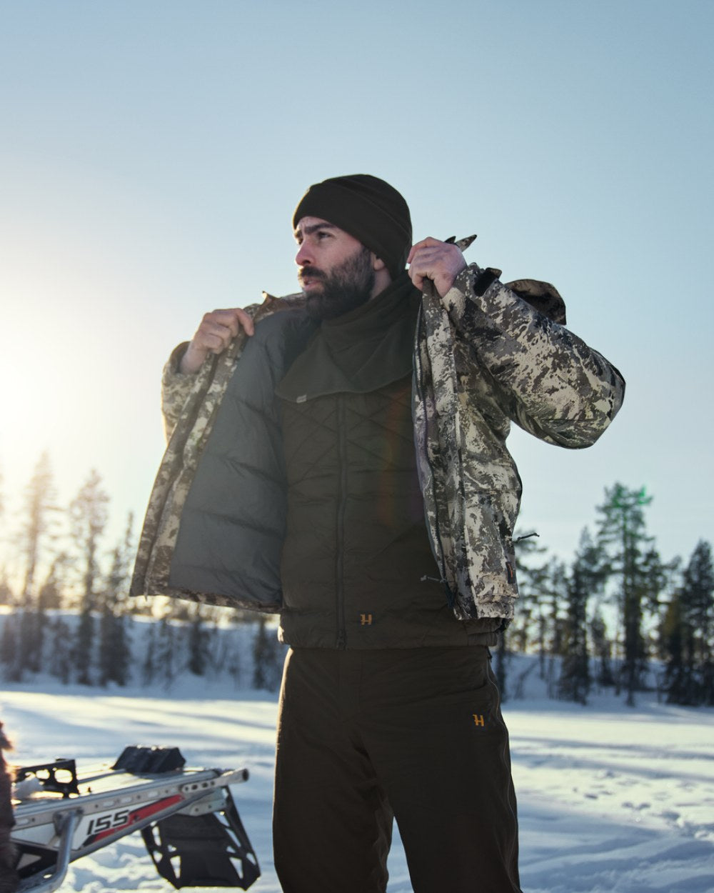 Willow Green Coloured Harkila Trygve Beanie on snow background #colour_willow-green