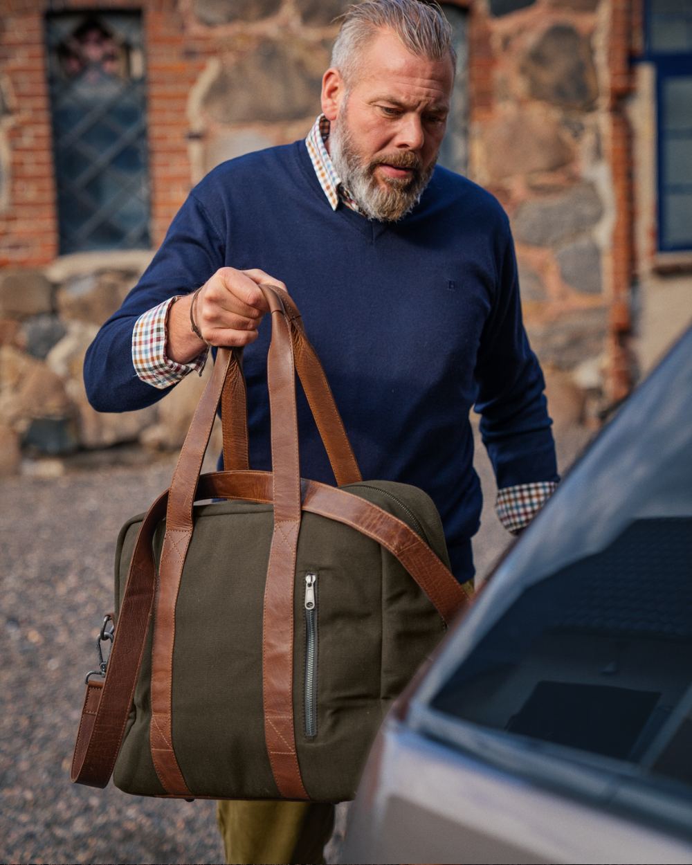 Warm Olive Coloured Harkila Weekend Bag 30L on outdoor background #colour_warm-olive