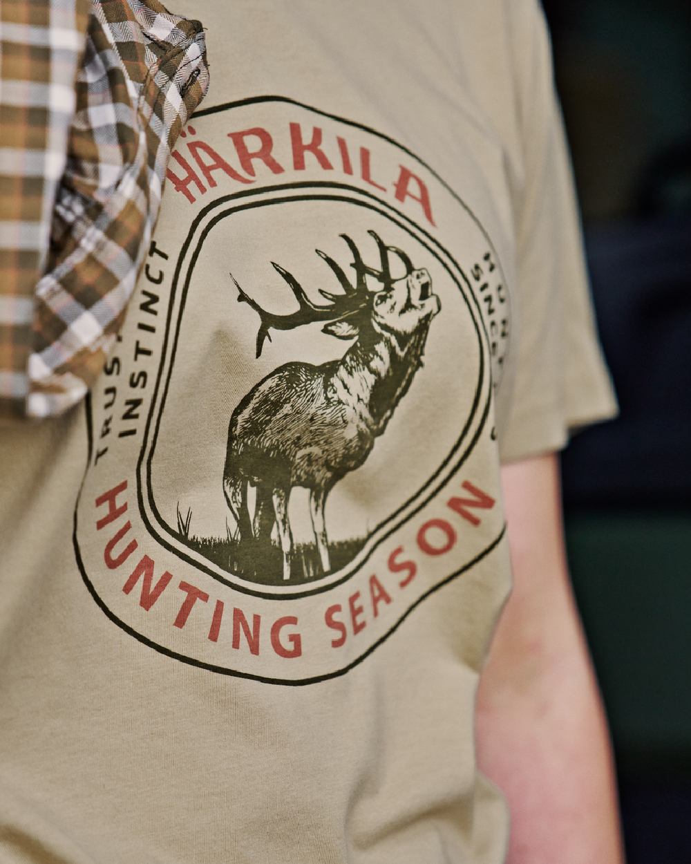 Sand Coloured Harkila Womens Stag Badge Short Sleeve T-Shirt on blurry background #colour_sand
