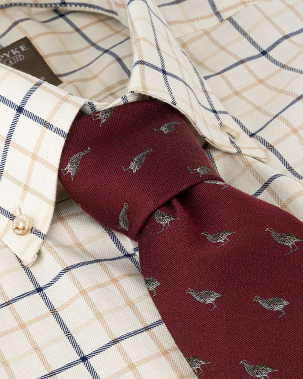Burgundy coloured Jack Pyke Silk Tie Partridge on shirt background #colour_burgundy