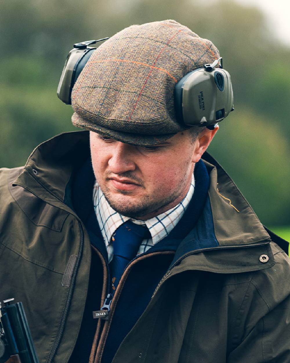 Tweed Brown Coloured Jack Pyke Wool Blend Tweed Flat Cap On A Blurry Background #colour_tweed-brown