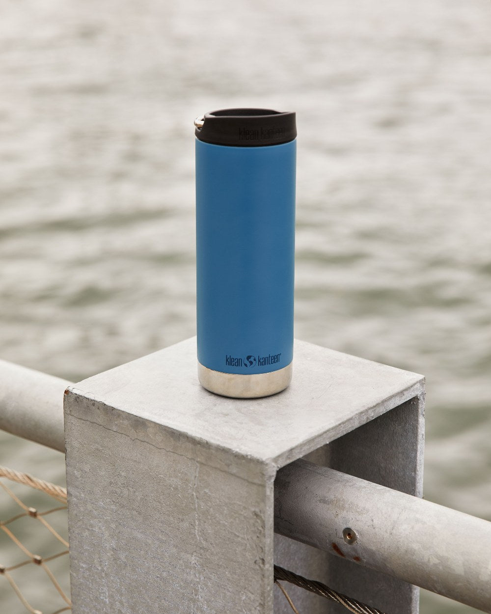Real Teal Coloured Klean Kanteen Insulated TKWide With Cafe Cap On A River Background #colour_real-teal