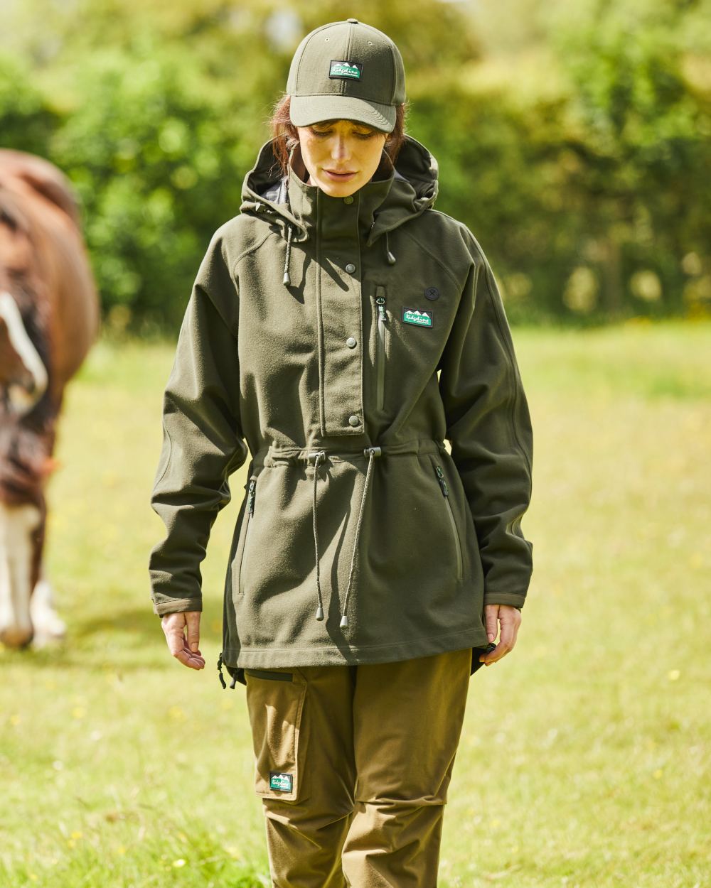 Deep Forest Coloured Ridgeline Ladies Monsoon II Waterproof Smock On A Field Background #colour_deep-forest