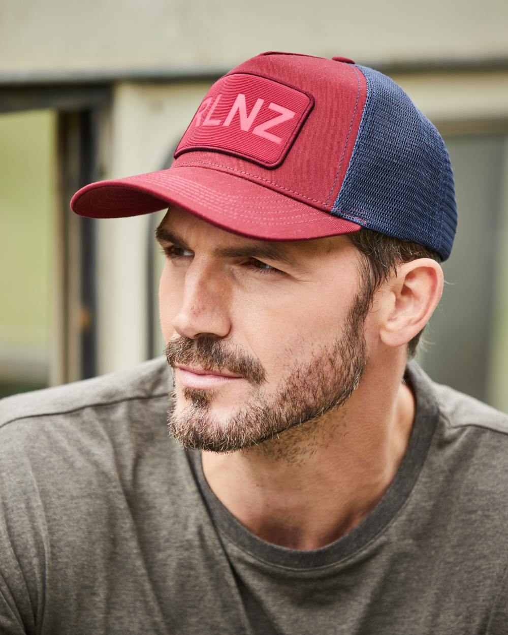 Rhubarb Coloured Ridgeline RLNZ Trucker Cap On A Street Background #colour_rhubarb