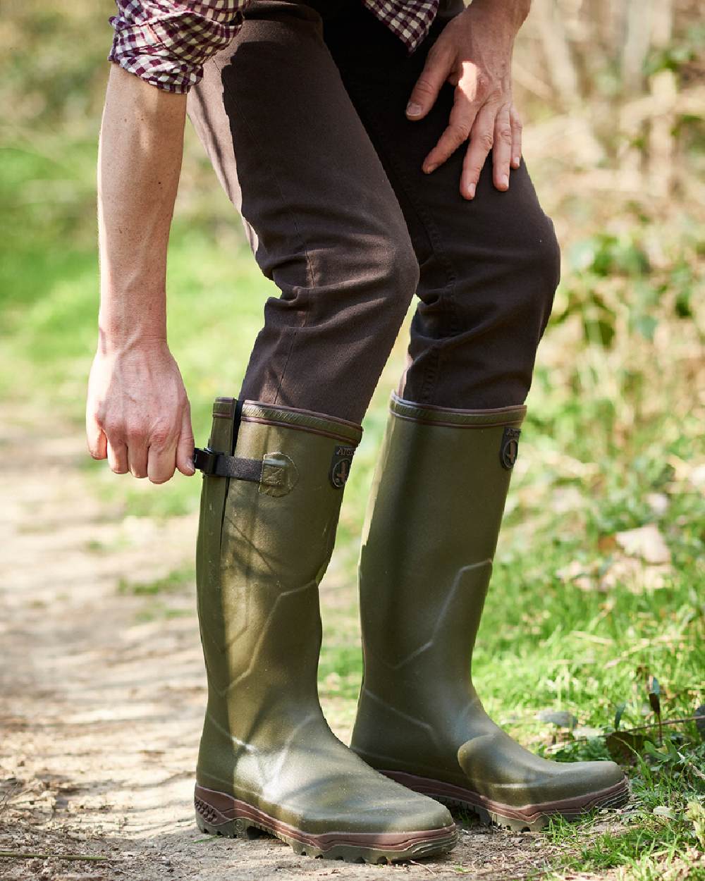 Kaki coloured Aigle Parcours 2 Vario Wellington Boots on forest background #colour_kaki