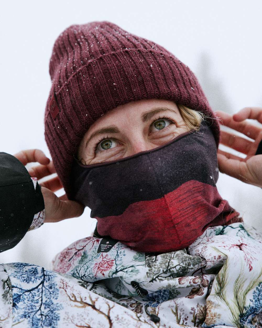 Maroon Coloured Buff Knitted Norval Beanie on snow background #colour_maroon