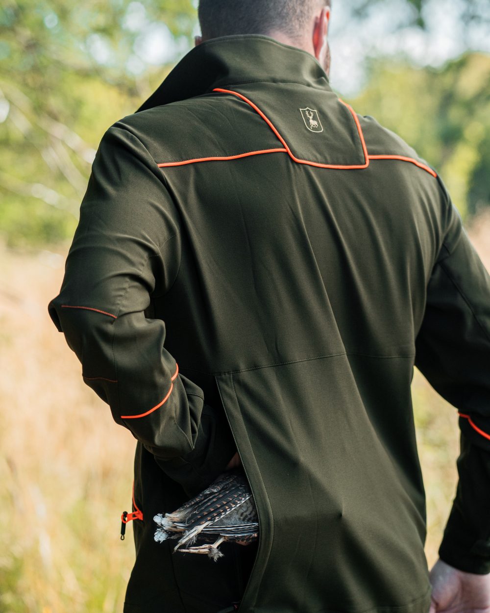 Forest Green coloured Deerhunter Chamois Jacket on forest background #colour_forest-green