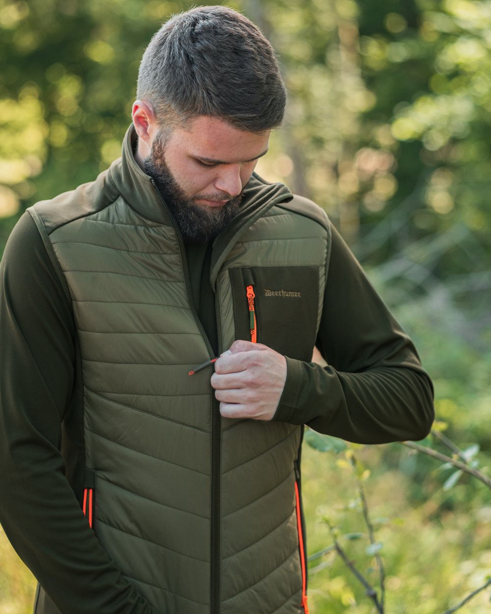 Forest Green coloured Deerhunter Chamois Padded Waistcoat on forest background #colour_forest-green