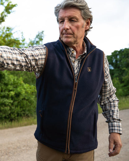 Dark Blue coloured Deerhunter Cumbria Fleece Waistcoat on forest background #colour_dark-blue