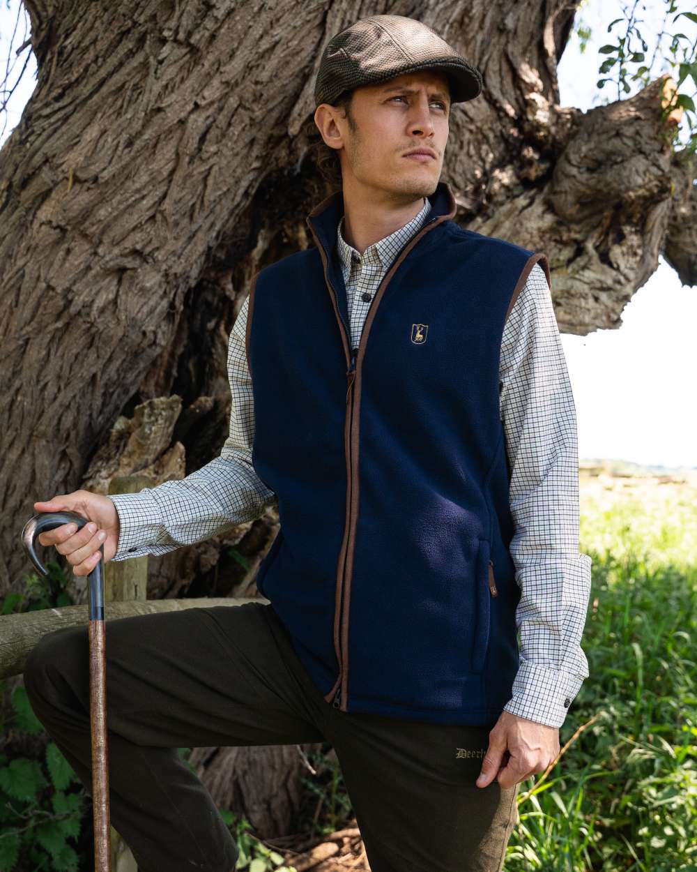 Dark Blue coloured Deerhunter Cumbria Fleece Waistcoat on forest background #colour_dark-blue