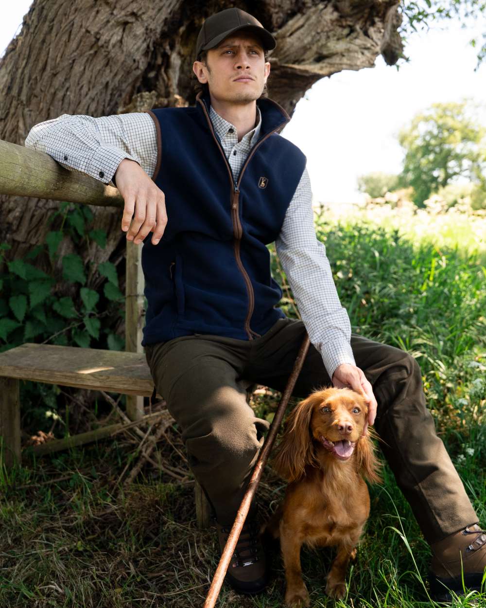Dark Blue coloured Deerhunter Cumbria Fleece Waistcoat on forest background #colour_dark-blue