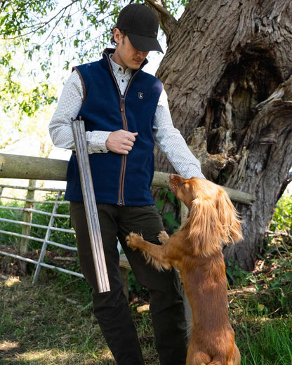 Dark Blue coloured Deerhunter Cumbria Fleece Waistcoat on forest background #colour_dark-blue
