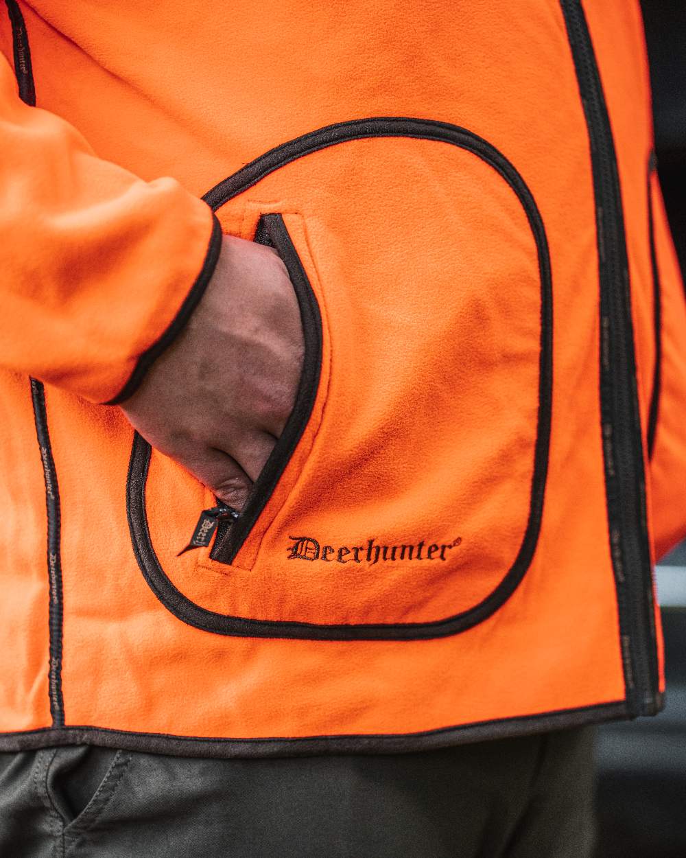 Canteen Orange coloured Deerhunter Gamekeeper Reversible Bonded Fleece Jacket on blurry background #colour_canteen-orange