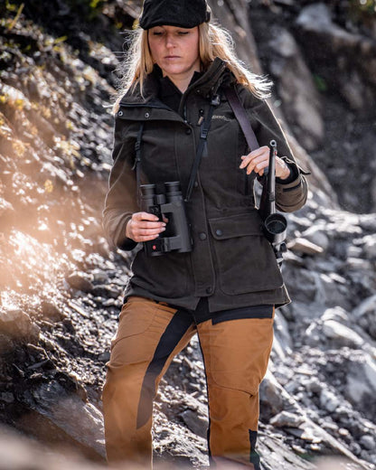 Bronze coloured Deerhunter Lady Ann Trousers on mountain background #colour_bronze